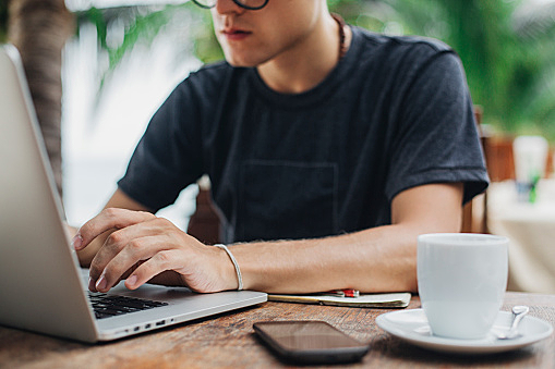 Caucasian man using laptop in cafe