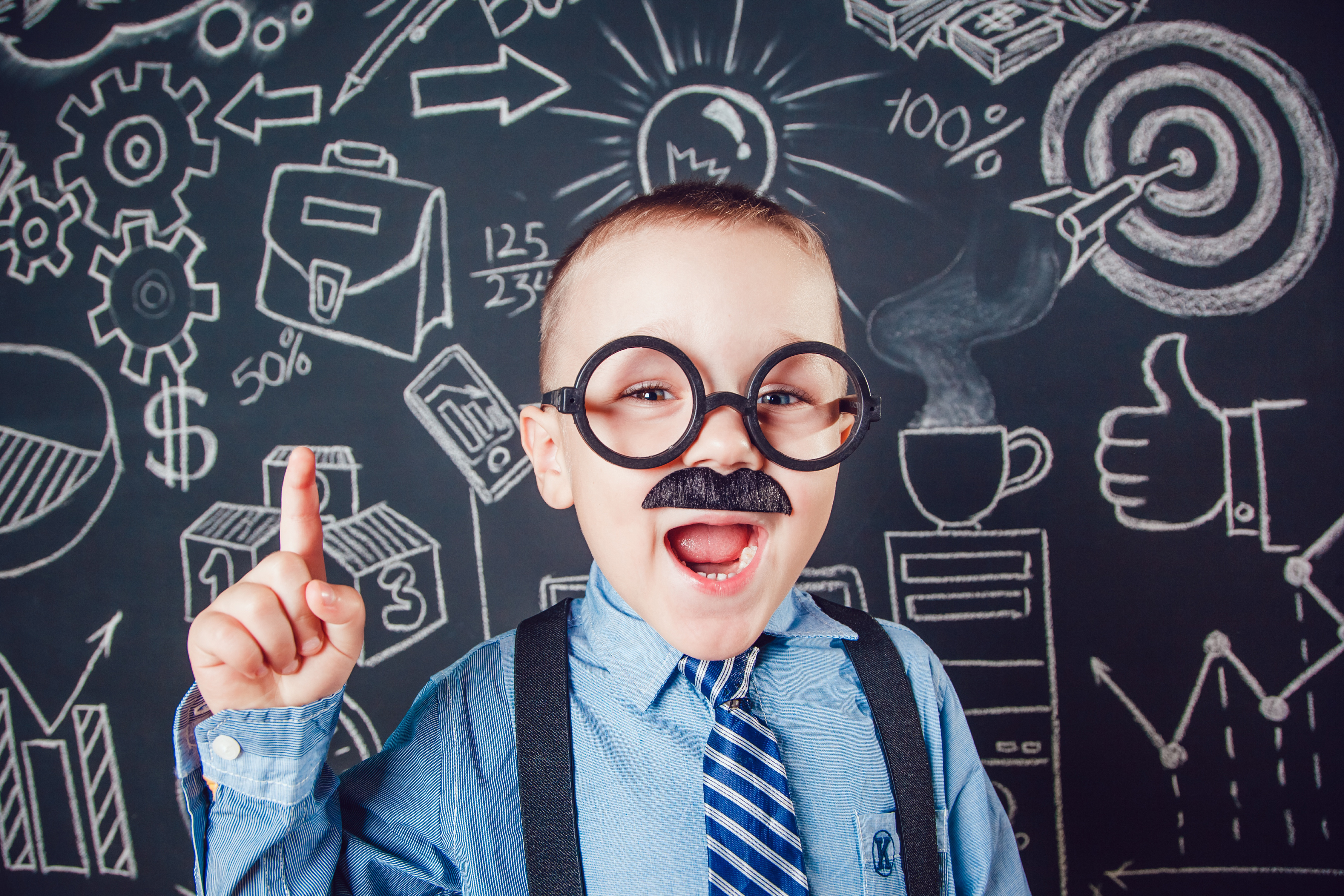 Little boy as businessman or teacher with mustache and glasses standing on dark background pattern. Wearing shirt, tie. Lifting a finger up