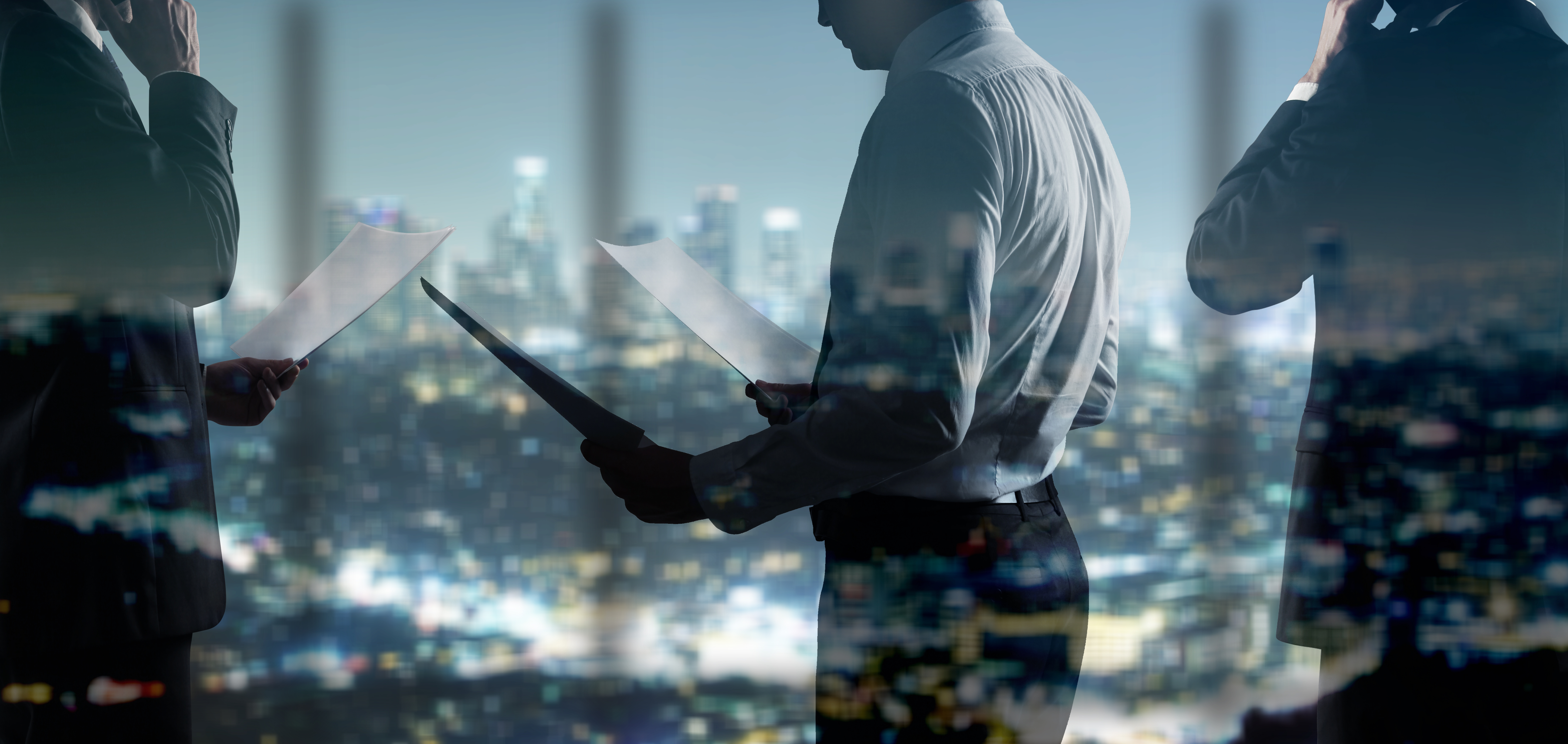 businessman with paper standing in night office
